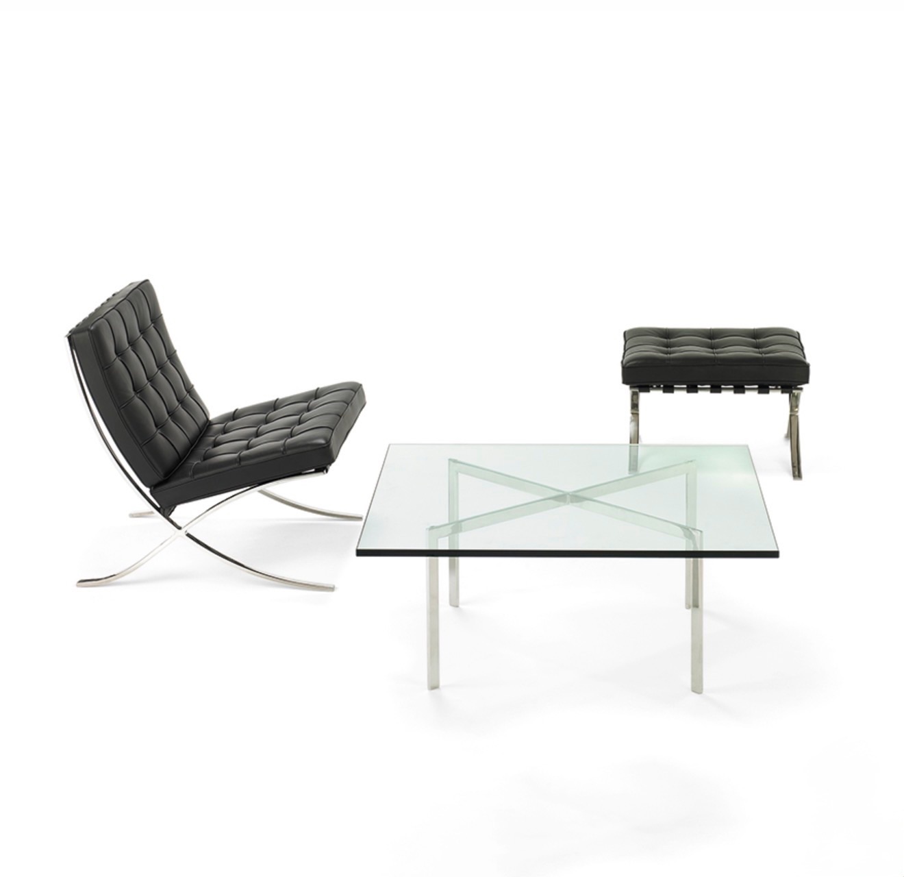 A black leather Barcelona chair and matching ottoman beside a glass-and-steel table